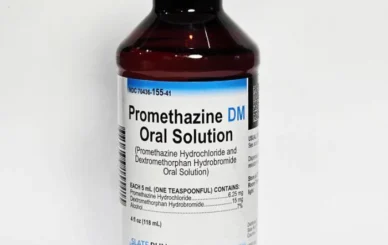 Promethazine DM syrup bottle with measuring cup for cough relief